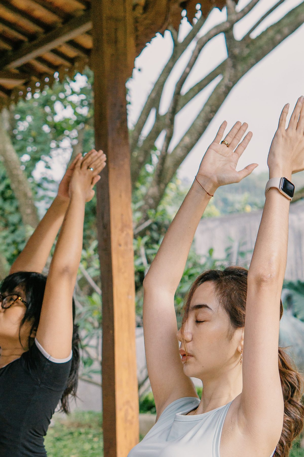 Practitioner lifting arms in an outdoor breath and movement practice