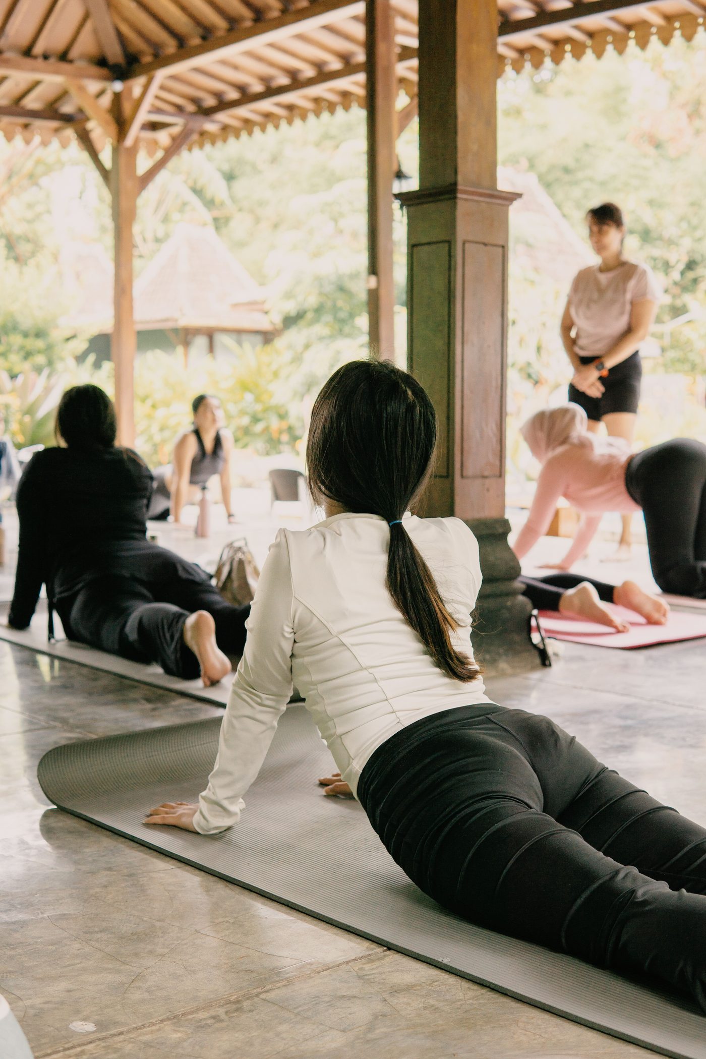 Students practicing yoga together in an open pavilion