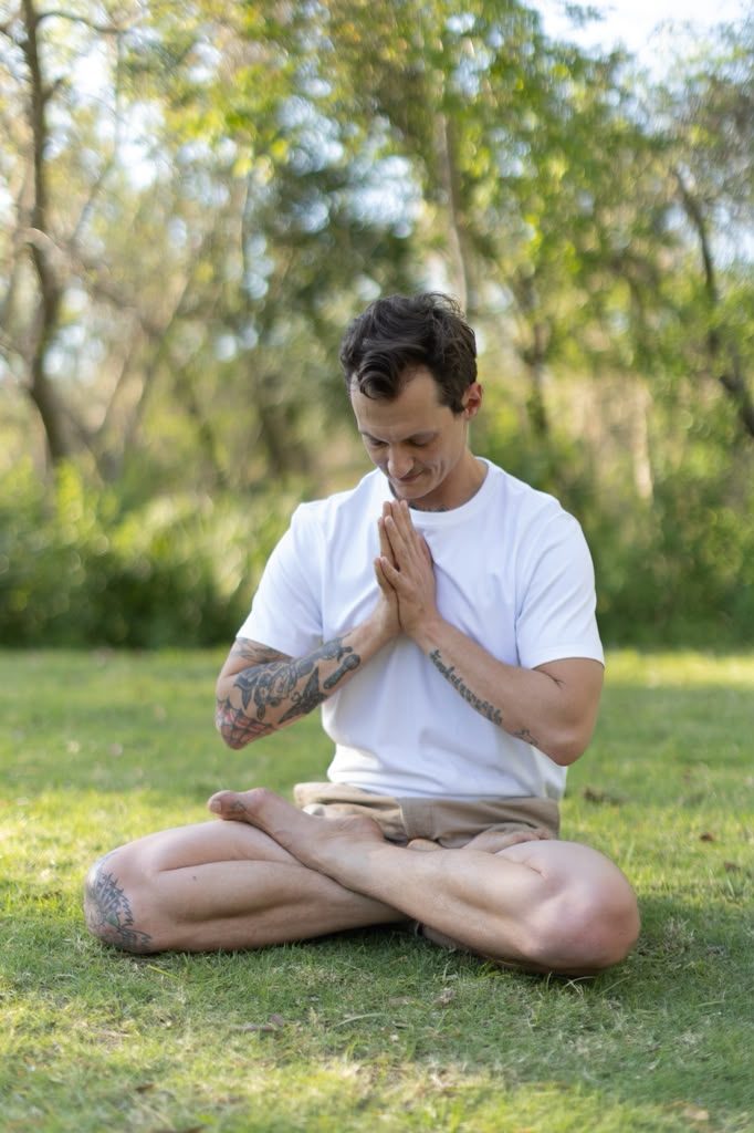 Nick Dearman in seated breath practice with hands at heart